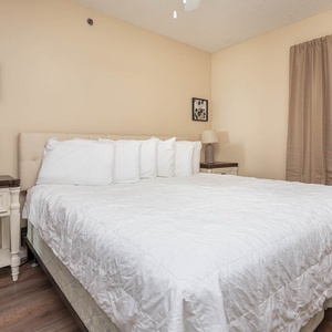 The master bedroom features a plush white bed, soft lighting, and warm beige tones for a restful retreat