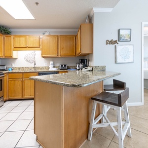 Warm wooden cabinetry complements the granite countertops in this inviting kitchen with a breakfast bar