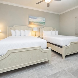 Inviting guest bedroom featuring two queen beds, soft lighting, and serene decor for restful nights