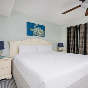 Cozy master bedroom featuring a plush king bed, decorative turtle art, and stylish lamps for a relaxing getaway