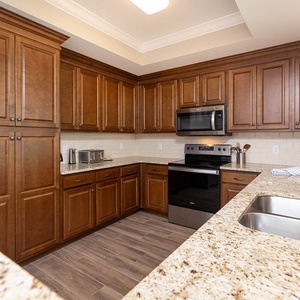 Prepare meals in this kitchen with elegant cabinetry, stainless appliances, and spacious countertops
