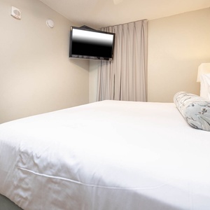 Relax in this comfortable bedroom featuring a plush king bed, soft linens, and a flat-screen TV for your entertainment