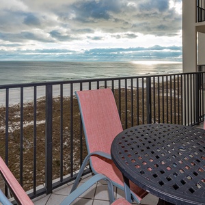 Relax on the balcony with a round table and chairs, enjoying sweeping views of the beach and tranquil gulf waters