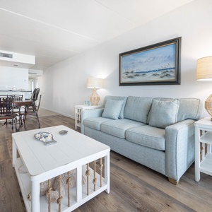 This living area features a comfortable sofa, a stylish coffee table, and a dining space, perfect for relaxation and meals