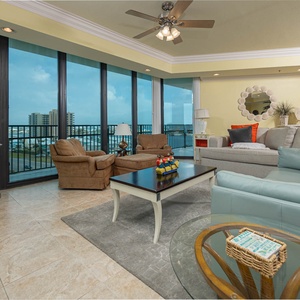 Unwind in the spacious living area with comfortable seating, a large TV, and stunning views through expansive windows