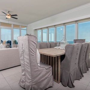 Relax at the dining table and gaze through glass walls to the expansive beach and coastline beyond