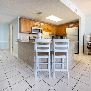 Gather around the breakfast bar or dining table, enjoying the open layout and easy access to the kitchen