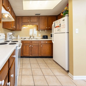 This kitchen features warm wood cabinetry, a full set of appliances, and a convenient coffee maker for your morning brew