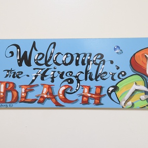 This vibrant sign welcomes guests to the beach, adding a cheerful touch to your vacation experience
