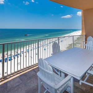 Savor the coastal breeze as you gather at the table, taking in the sweeping beach views from your balcony retreat