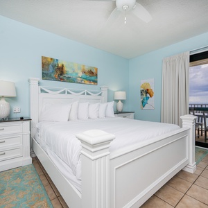 The serene atmosphere of this master bedroom with a king bed and balcony access is perfect for a coastal getaway
