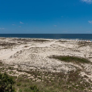 This expansive view showcases the beach and dunes, inviting relaxation and enjoyment of the coastal scenery