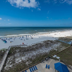Enjoy a breathtaking view of the beach, dotted with colorful umbrellas and lounge chairs, from the balcony area