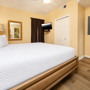 Cozy bedroom with a comfortable king bed, a flat-screen TV, and warm tones for a restful stay