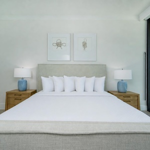 Retreat to this serene master bedroom with a cozy king bed, stylish lamps, and calming artwork