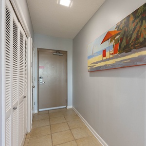 Step into a welcoming entryway adorned with a beach-themed painting and convenient laundry area