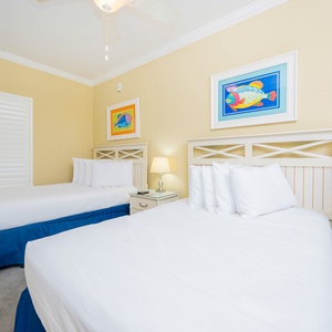 Guest bedroom featuring two double beds with colorful fish artwork, creating a cheerful and relaxing atmosphere