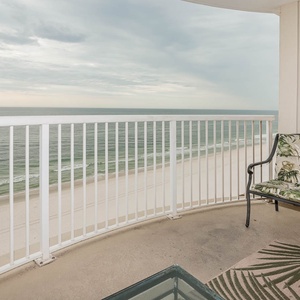 This balcony offers a serene beachfront view, featuring comfortable seating and a relaxing atmosphere