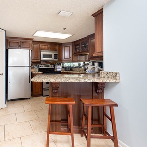 Gather around the granite countertop bar with seating, perfect for casual meals in a welcoming kitchen
