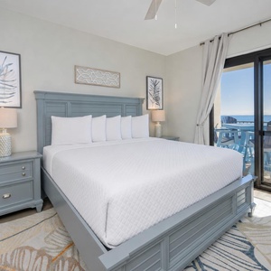 King bed in the master suite invites restful nights with coastal breezes carried through sliding glass doors