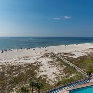 Tranquil beach with colorful umbrellas and a sparkling pool, perfect for relaxation and enjoyment