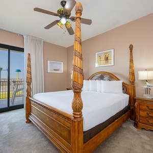 Enjoy restful nights in this master bedroom featuring a four-poster king bed and easy access to the outdoor patio