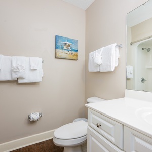 Enjoy a relaxing shower after a day of adventure in this guest bath with coastal accents and fluffy towels