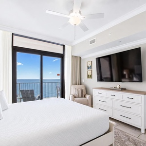 Unwind in elegant master bedroom featuring a king bed, a large TV, and stunning views through the sliding glass door