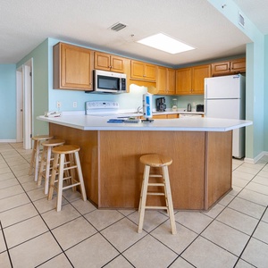 Gather around the spacious kitchen bar with seating, perfect for enjoying meals and conversations in a welcoming space