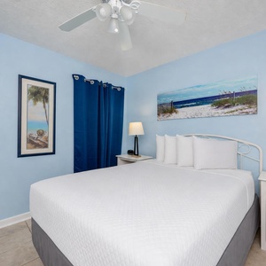White linens cool your queen guest suite as you prepare for a peaceful night's rest under the ceiling fan