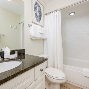 Refreshing guest bathroom featuring a granite countertop, modern fixtures, and a relaxing tub/shower combo