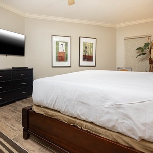 Retreat to this serene master bedroom featuring a plush king bed, stylish decor, and a large TV for your entertainment