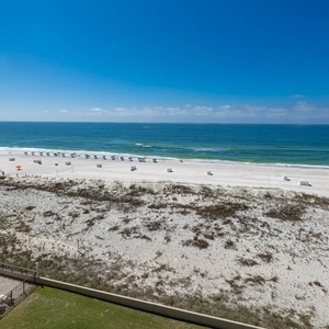 Gaze at the expansive coastline and gentle waves from your comfortable balcony seating, perfect for relaxation