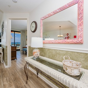 Step into a welcoming entryway featuring a stylish console table, seashell decor, and views of the inviting living area
