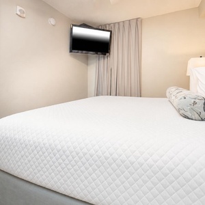Rest comfortably in this bedroom featuring a plush king bed, soft linens, and a mounted TV for your entertainment