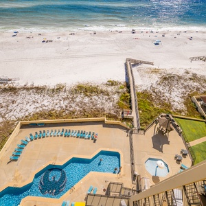 Relaxing view of the beach and pool area, featuring inviting lounge chairs and a relaxing hot tub