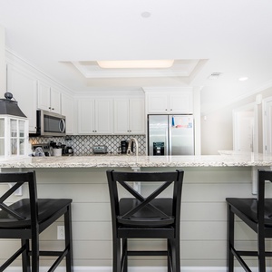 Gather around the wet bar with friends, mixing drinks and enjoying the casual vibe of your beachside retreat