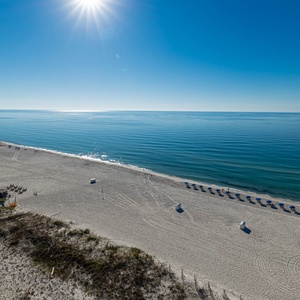 Gaze at the serene water and beach from your balcony, perfect for relaxing and soaking in the morning sun