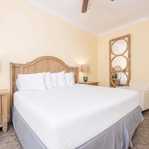 Calming guest bedroom featuring a plush king bed, stylish decor, and a cozy armchair for relaxation