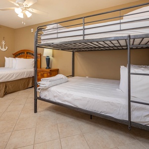 A full over full bunk bed complement a queen bed, creating a welcoming retreat for families or groups in this guest room