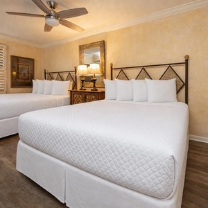 This guest bedroom features two double beds, decorative wall art, and warm tones, creating a welcoming atmosphere