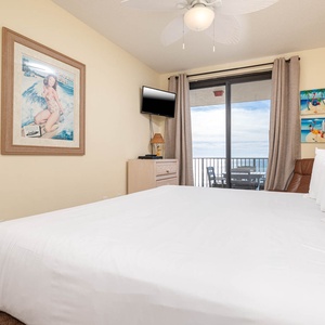 Relax in the spacious master bedroom with a king bed, a TV, and beautiful beach balcony views