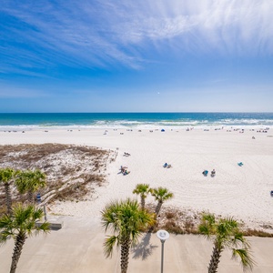 Bright blue sky stretches above the shore where gentle waves lap and laughter drifts on the breeze