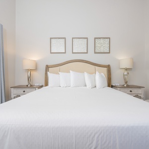 Bright and inviting master bedroom featuring a king bed, stylish artwork, and elegant bedside lamps for a restful retreat