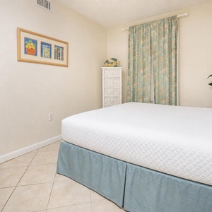 Relax in this inviting guest bedroom featuring a queen bed, cheerful decor, and natural light from the window