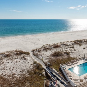 Breathtaking view of the sparkling blue water and pristine beach from a relaxing poolside retreat