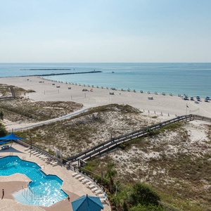 Take a refreshing dip in the pool while enjoying views of the beach and lounge chairs set up for your relaxation