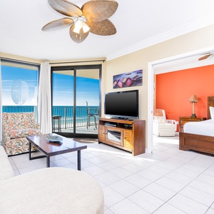 Relax in the inviting living area with a cozy sofa with queen sleeper, vibrant decor, and a beachfront balcony view