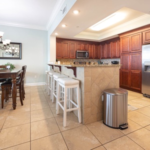 Enjoy meals at the stylish dining table or the breakfast bar, surrounded by warm wood tones and inviting decor
