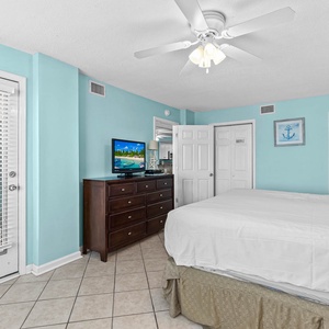 Bright and inviting master bedroom featuring a king bed, a TV, and refreshing aqua walls for a relaxing getaway